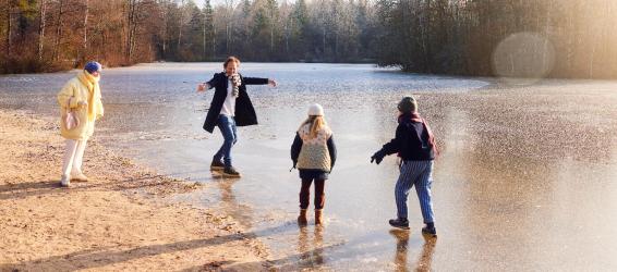 Une famille s'amuse en bord de lac en hiver